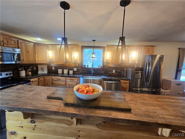 kitchen with plenty of natural light, pendant lighting, a breakfast bar area, and stainless steel appliances