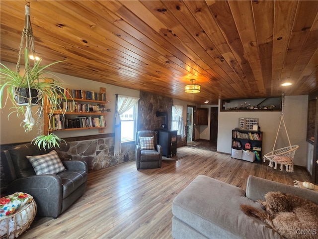 living room with a wood stove, hardwood / wood-style floors, and wooden ceiling