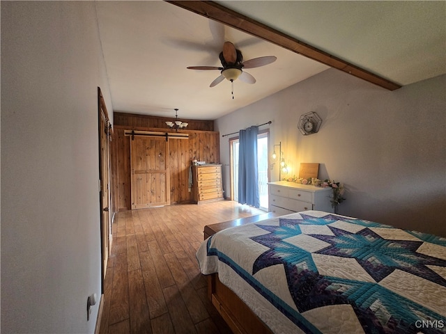 bedroom featuring light hardwood / wood-style floors, wood walls, and ceiling fan