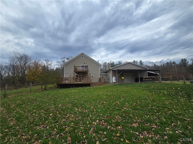 rear view of house featuring a wooden deck and a lawn