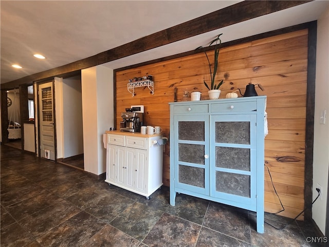 bar featuring butcher block counters, wood walls, and white cabinets