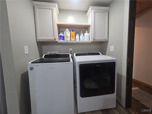 washroom featuring separate washer and dryer, dark wood-type flooring, and cabinets