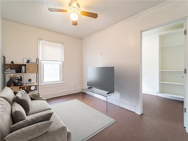 living room with built in features, dark hardwood / wood-style floors, and ceiling fan