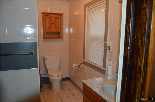 bathroom featuring vanity, toilet, tile patterned flooring, and tile walls