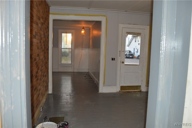 doorway featuring brick wall and dark hardwood / wood-style flooring