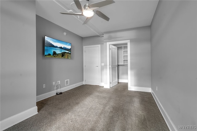 unfurnished bedroom featuring ceiling fan, carpet flooring, a closet, and a walk in closet