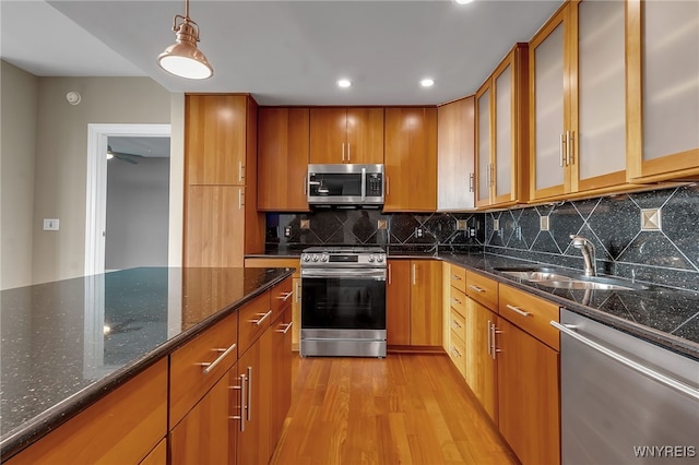 kitchen featuring pendant lighting, appliances with stainless steel finishes, sink, and backsplash