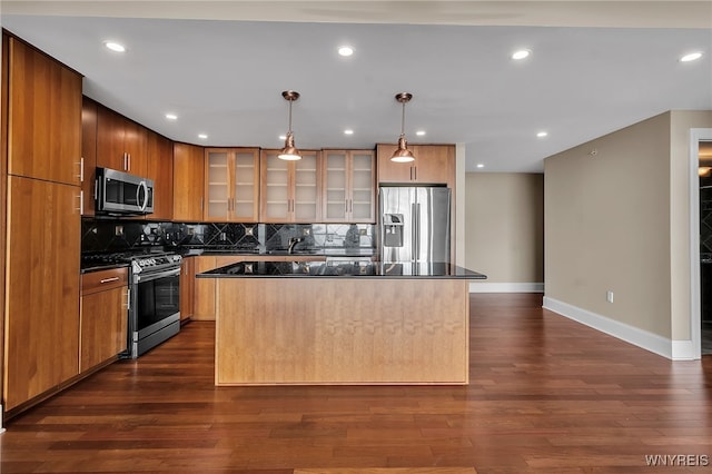 kitchen with decorative light fixtures, a center island, appliances with stainless steel finishes, dark hardwood / wood-style floors, and decorative backsplash