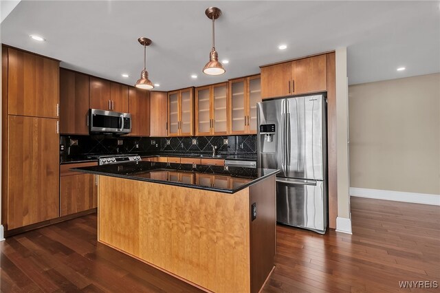 kitchen featuring stainless steel appliances, dark hardwood / wood-style floors, a center island, and hanging light fixtures