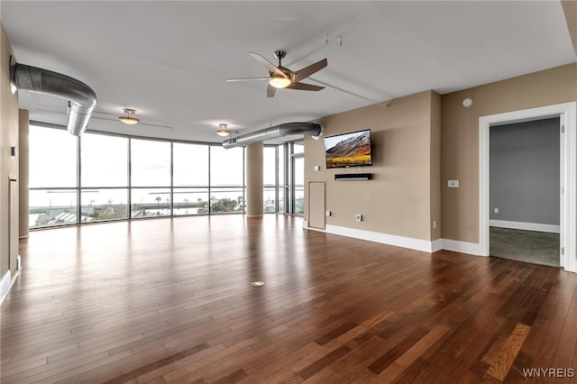 unfurnished living room featuring hardwood / wood-style floors, a wall of windows, and ceiling fan