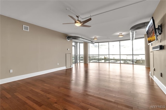 interior space with hardwood / wood-style floors, a wall of windows, and ceiling fan