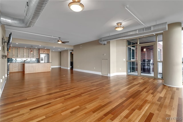 unfurnished living room featuring ceiling fan and hardwood / wood-style floors