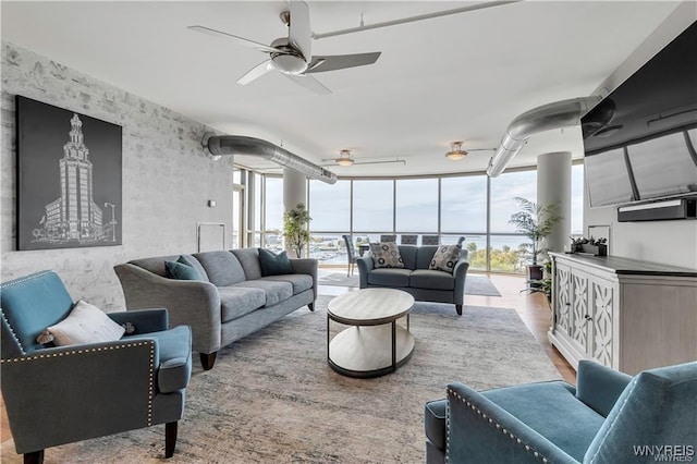 living room with ceiling fan, floor to ceiling windows, and hardwood / wood-style floors