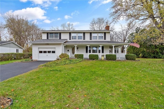 view of front of house featuring covered porch, a garage, and a front lawn