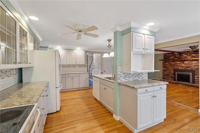 kitchen with pendant lighting, white cabinets, and light wood-type flooring