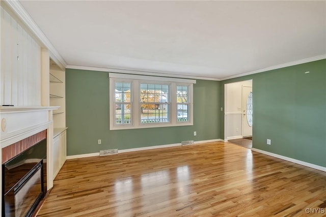 unfurnished living room featuring crown molding, light hardwood / wood-style flooring, and a brick fireplace