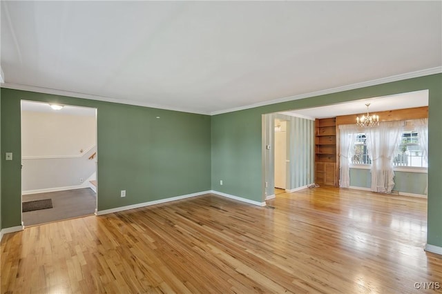 unfurnished room with light hardwood / wood-style flooring, a notable chandelier, and crown molding