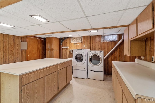 laundry area with cabinets, independent washer and dryer, and wooden walls