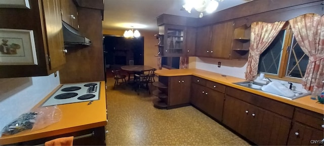 kitchen featuring dark brown cabinetry, a notable chandelier, sink, and white electric cooktop