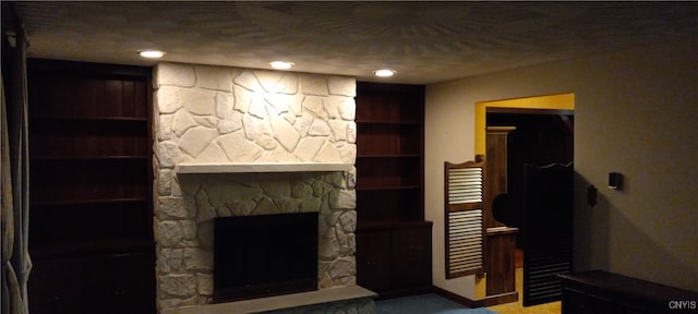 living room with built in shelves, carpet floors, and a fireplace