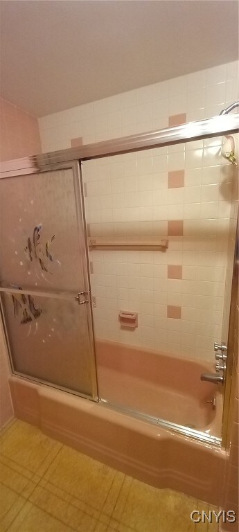 bathroom featuring shower / bath combination with glass door