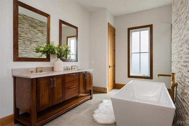 bathroom featuring tile patterned flooring, a bathtub, a wealth of natural light, and vanity