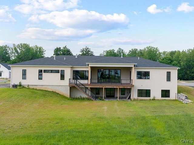 rear view of property featuring a deck and a yard