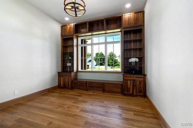 empty room with an inviting chandelier and dark wood-type flooring