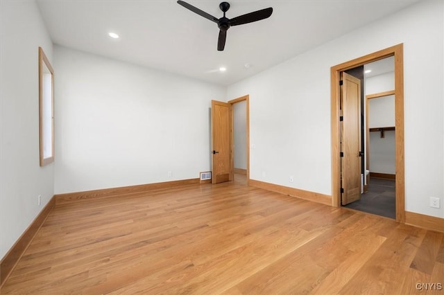 unfurnished bedroom with ceiling fan, light hardwood / wood-style flooring, a spacious closet, and a closet