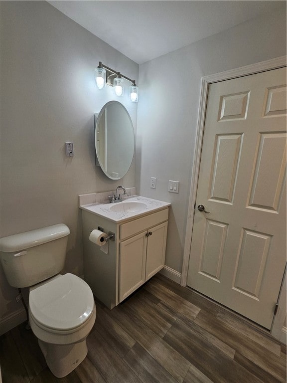 bathroom with hardwood / wood-style floors, vanity, and toilet