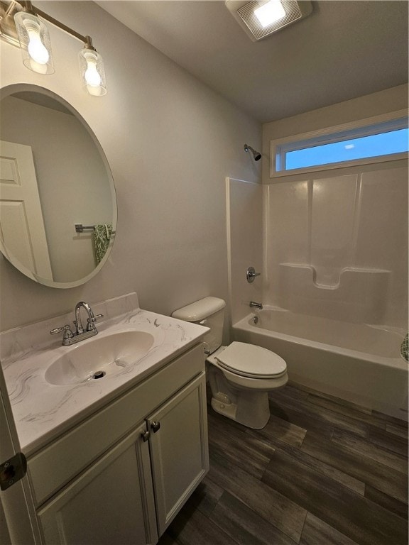 full bathroom featuring bathing tub / shower combination, vanity, hardwood / wood-style flooring, and toilet