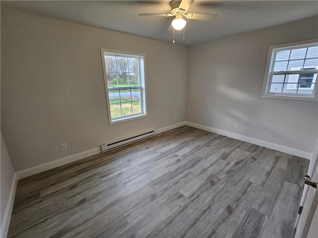 unfurnished room with light hardwood / wood-style floors, ceiling fan, and a baseboard heating unit