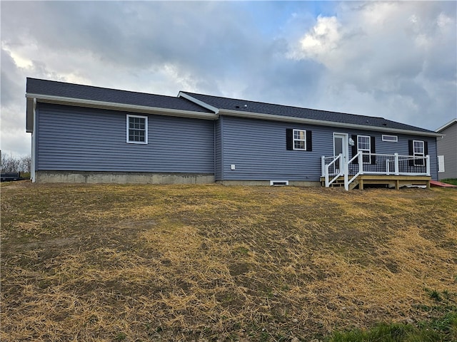 back of house featuring a lawn and a deck