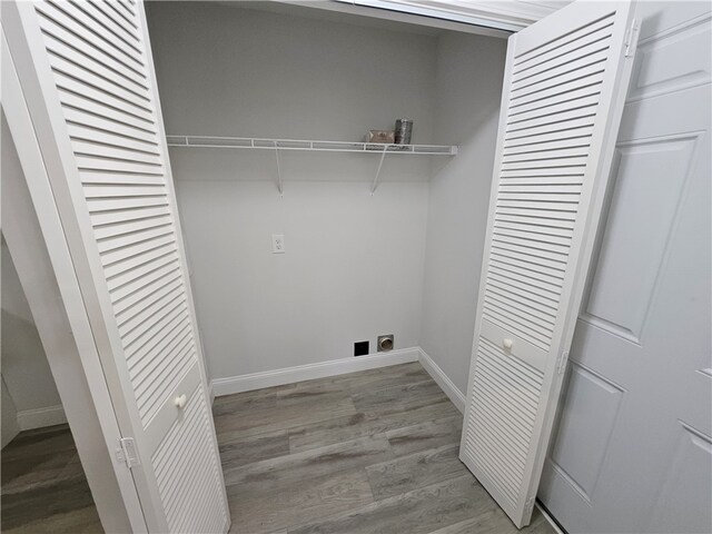 washroom featuring hookup for an electric dryer and light hardwood / wood-style floors