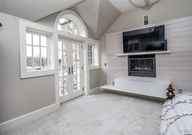 interior space with french doors, light colored carpet, and lofted ceiling