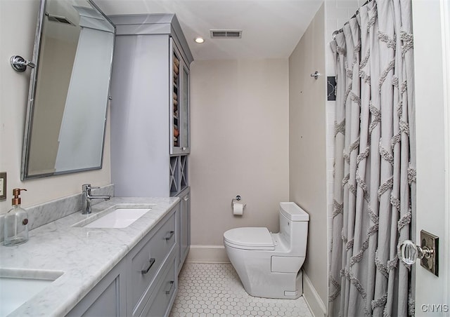 bathroom featuring toilet, vanity, a shower with shower curtain, and tile patterned floors