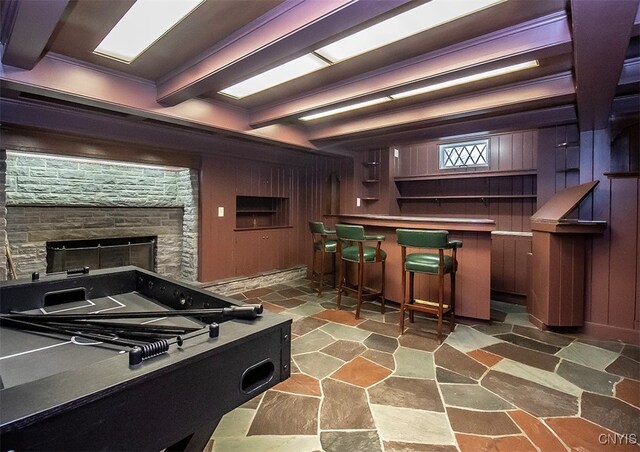 recreation room with bar area, wooden walls, and beam ceiling