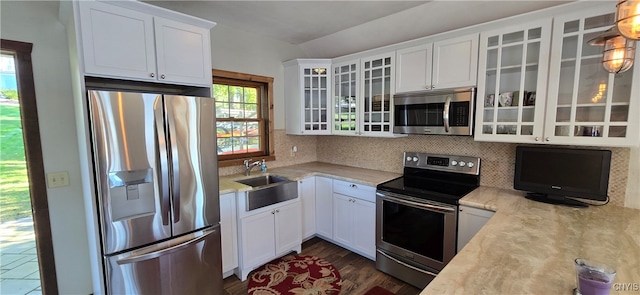 kitchen featuring tasteful backsplash, stainless steel appliances, white cabinetry, dark hardwood / wood-style flooring, and sink