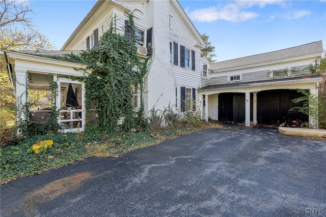 view of side of home with a garage and cooling unit