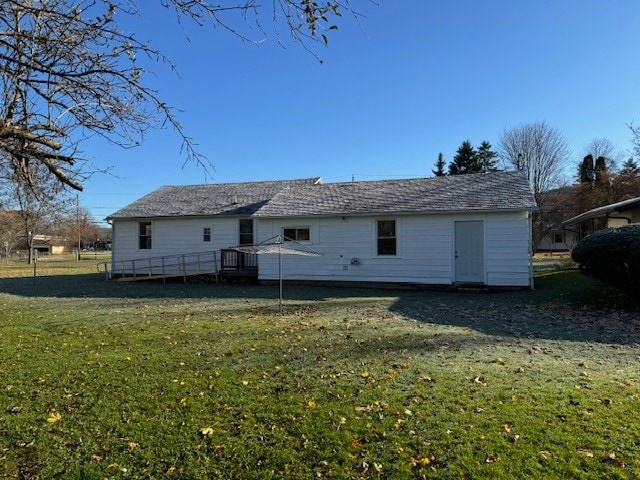 rear view of property featuring a wooden deck and a yard