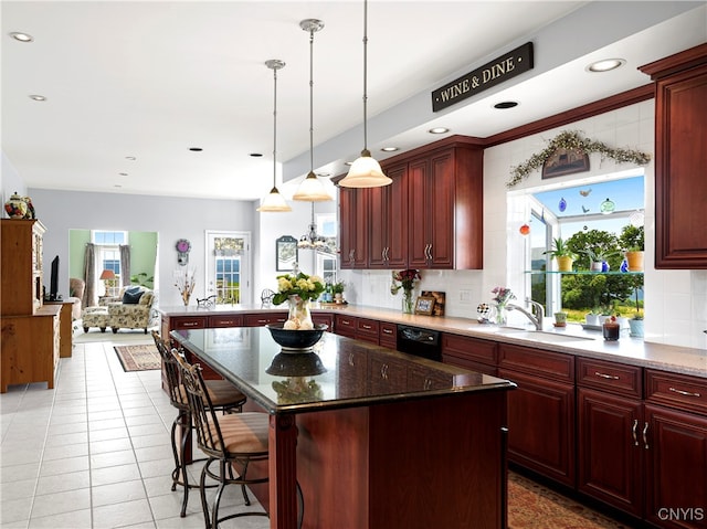 kitchen with a center island, sink, a breakfast bar area, and plenty of natural light