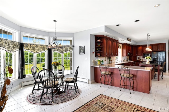 kitchen with black appliances, kitchen peninsula, light tile patterned floors, a baseboard radiator, and a chandelier