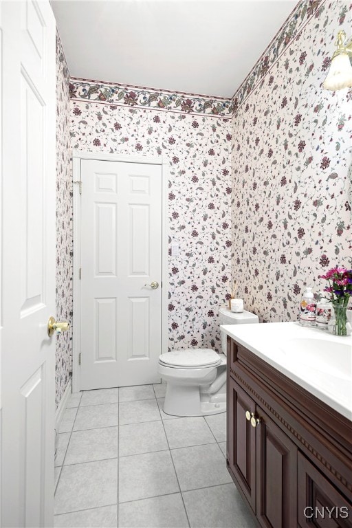 bathroom with toilet, vanity, and tile patterned floors