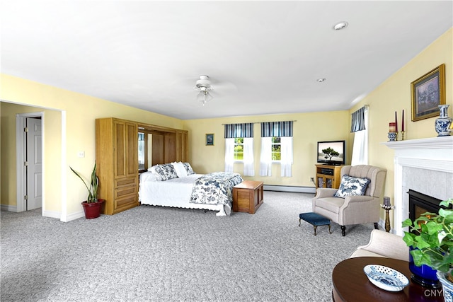 bedroom featuring ceiling fan, baseboard heating, a tile fireplace, and carpet floors