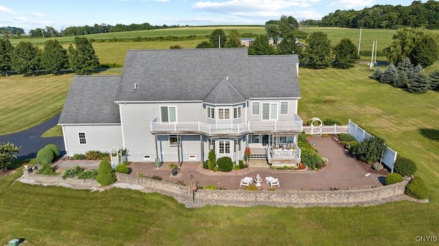 back of house with a lawn and a rural view