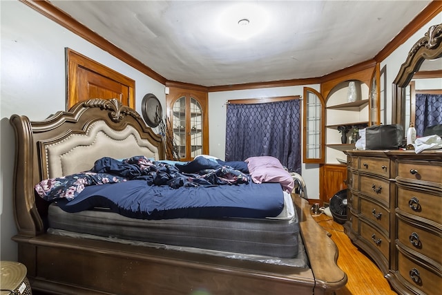 bedroom featuring light hardwood / wood-style flooring and crown molding