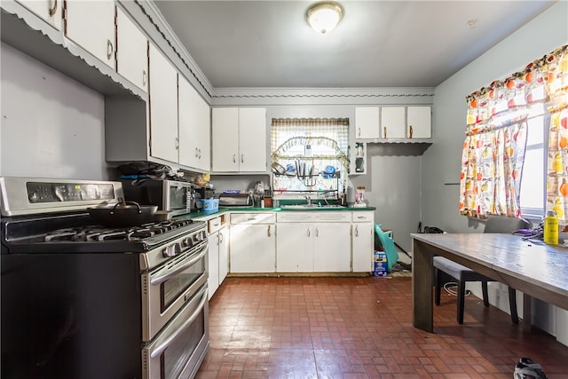 kitchen with white cabinets, stainless steel appliances, sink, and plenty of natural light