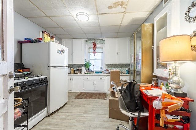 kitchen featuring backsplash, a drop ceiling, white cabinets, white appliances, and light hardwood / wood-style flooring