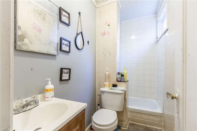 full bathroom with toilet, vanity, and tiled shower / bath