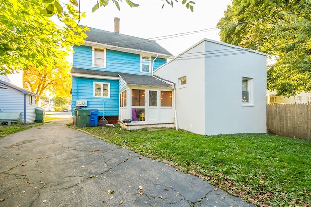 back of house featuring a sunroom and a yard